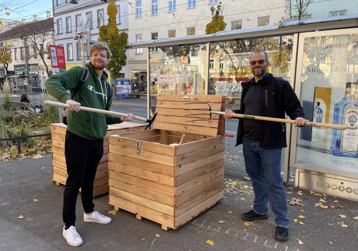 neu aufgestellter Kompostcontainer und Kompostierer*innen mit Werkzeug